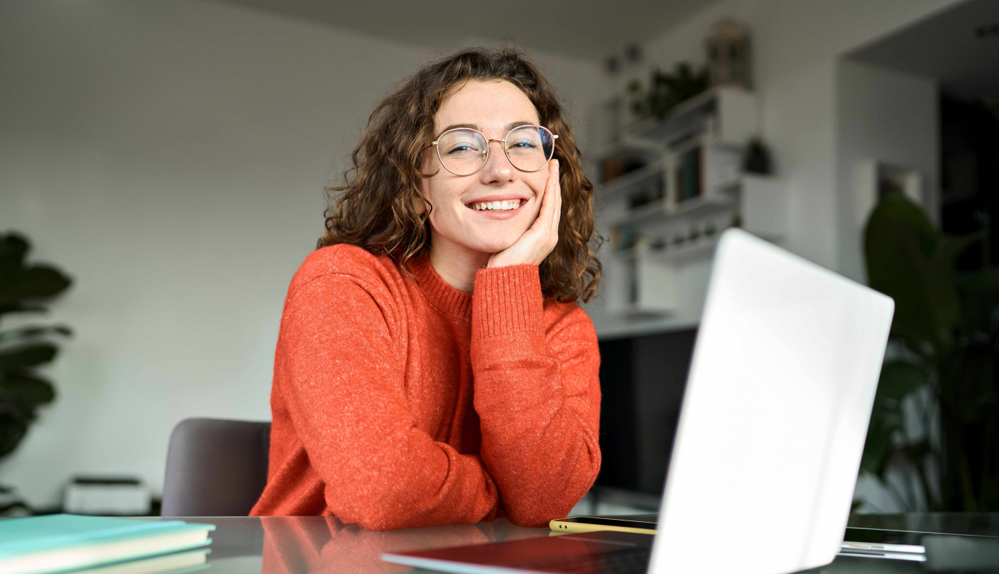 Junge Frau sitzt vor ihrem Laptop als Vorbereitung auf die Berufsreifeprüfung