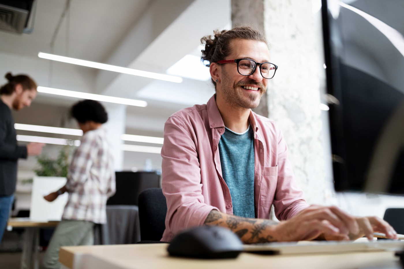 Junger Mann arbeitet mit Freude an deinem Computer