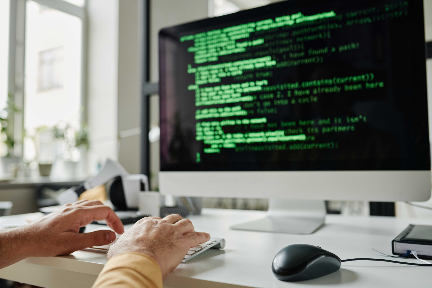 Mann programmiert IT-Anwendungen an seinem Computer