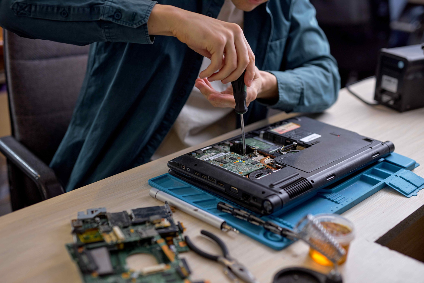 Mann schraubt an der Hardware eines Laptops