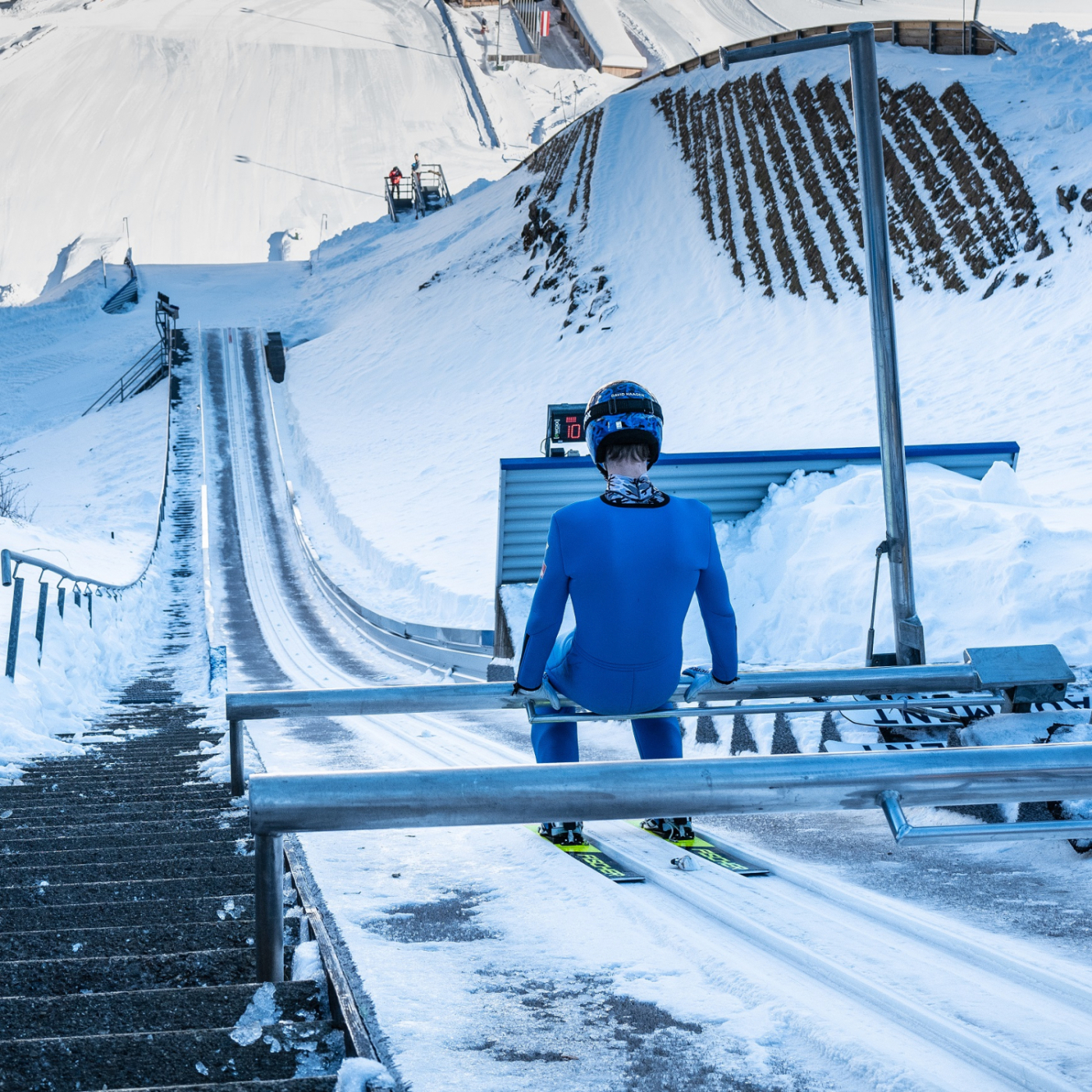 Junger Mann kurz vor dem Start beim Skispringen auf einer Schanze