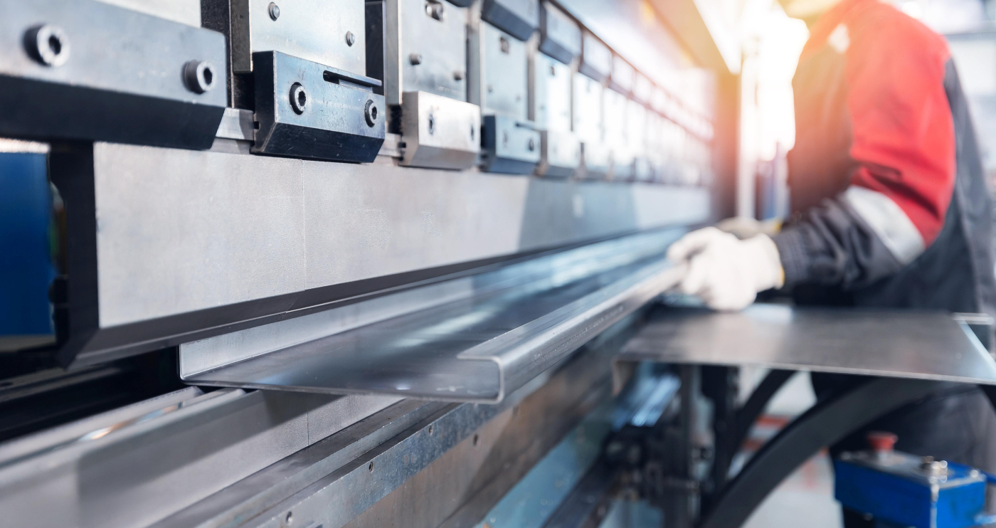 Mann in der Metalltechnik mit Sicherheitskleidung beim Biegen von Metall