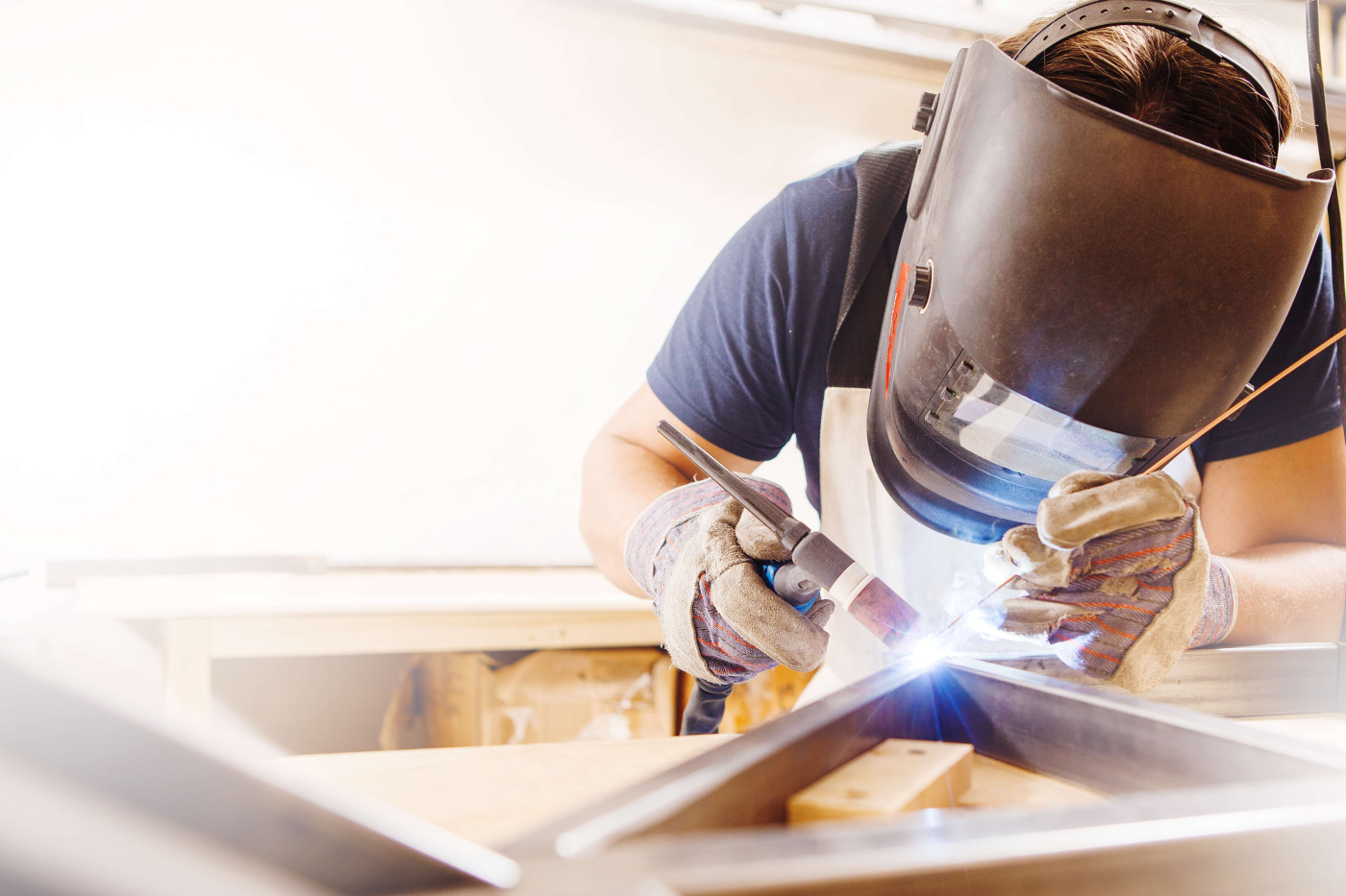 Mann mit Schutzhelm beim Schweißen in der Branche Schweißtechnik