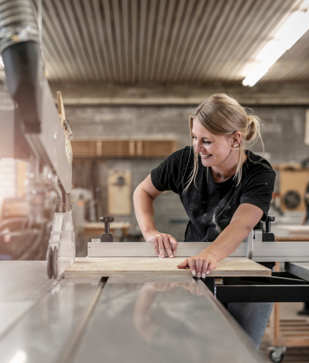 Junge Frau sägt ein Stück Holz an einer Kreissäge zu, Ausbildung Werkmeisterschule